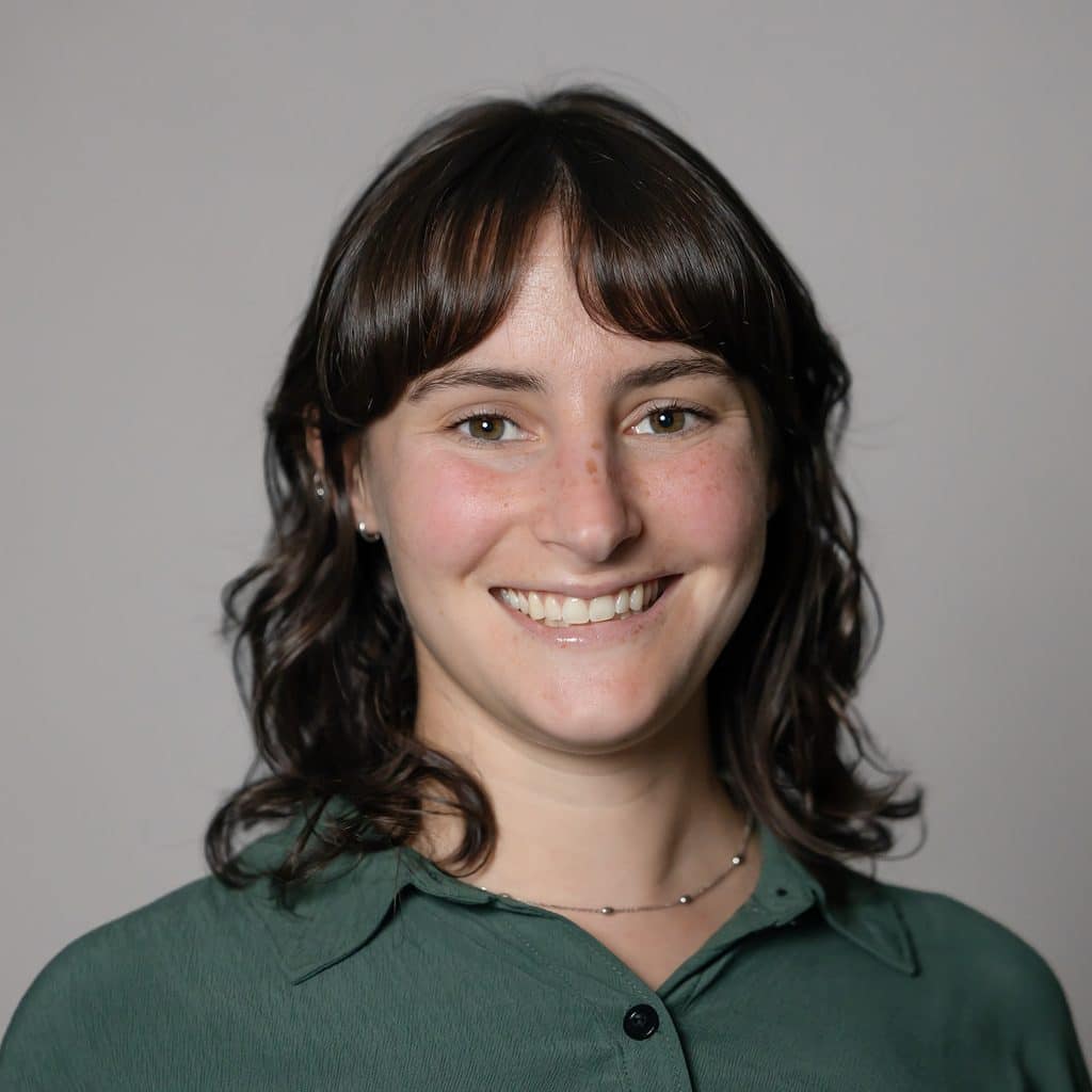 A young woman with brown hair smiles at the camera.