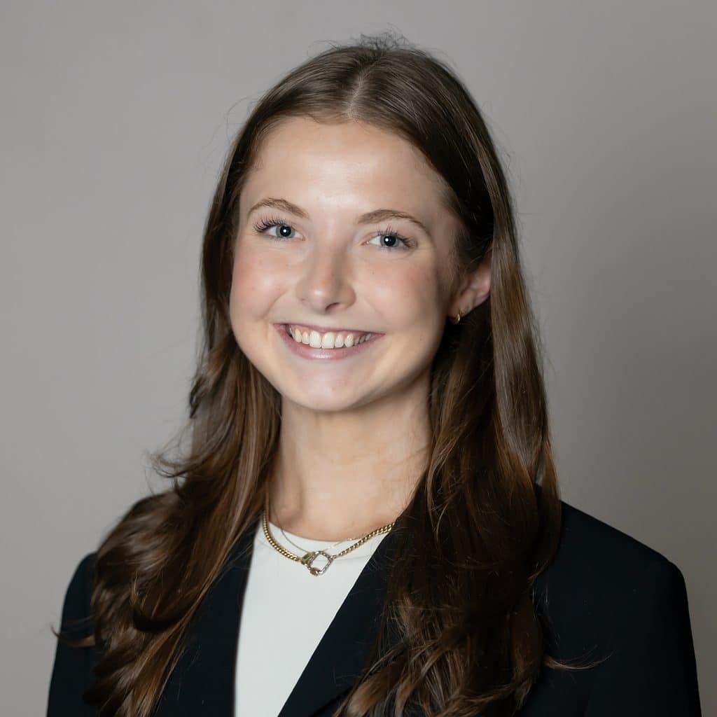 A young woman with long light brown hair smiling in a professional headshot.